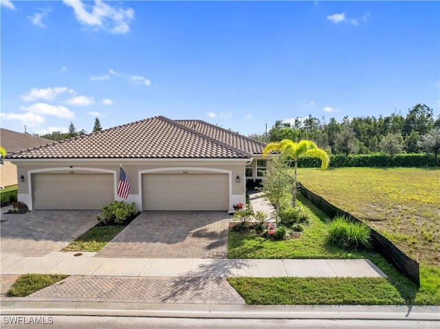 view of front of house featuring a tile roof, decorative driveway, a garage, and stucco siding