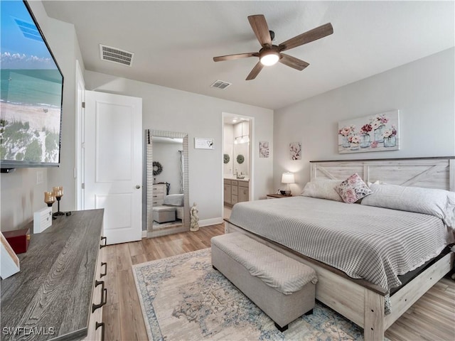 bedroom with light hardwood / wood-style floors, ensuite bath, and ceiling fan