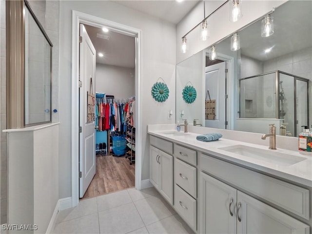 bathroom featuring vanity, tile patterned floors, and a shower with shower door