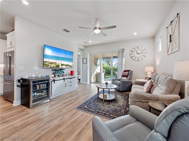 living room featuring wine cooler, ceiling fan, and light hardwood / wood-style flooring