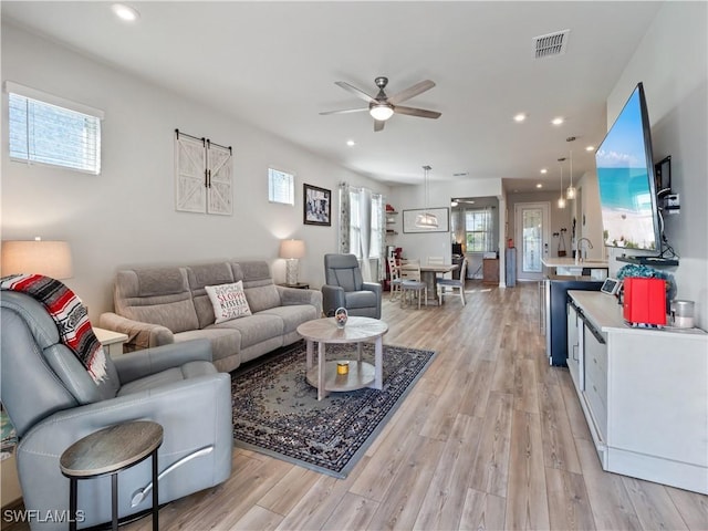 living room featuring light wood-type flooring and ceiling fan