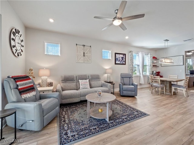 living room featuring ceiling fan and light hardwood / wood-style floors