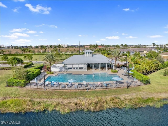 view of swimming pool with a water view and a lawn