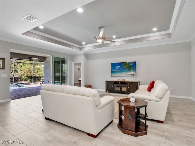 living room with ornamental molding and a raised ceiling