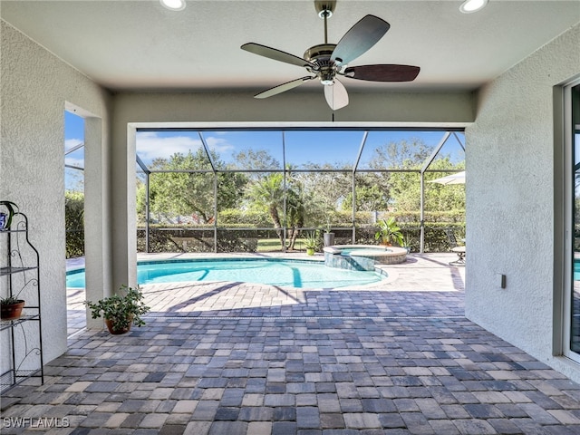 view of swimming pool with ceiling fan, a lanai, an in ground hot tub, and a patio area