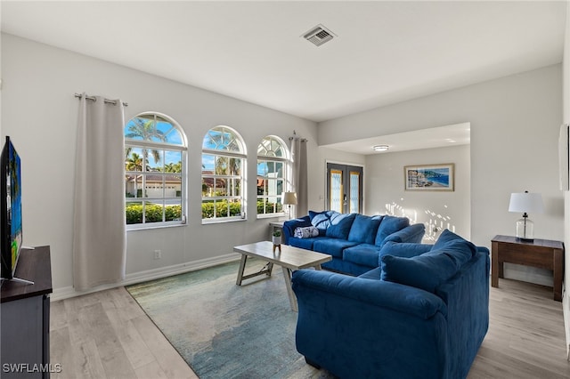 living room with light wood-type flooring and french doors