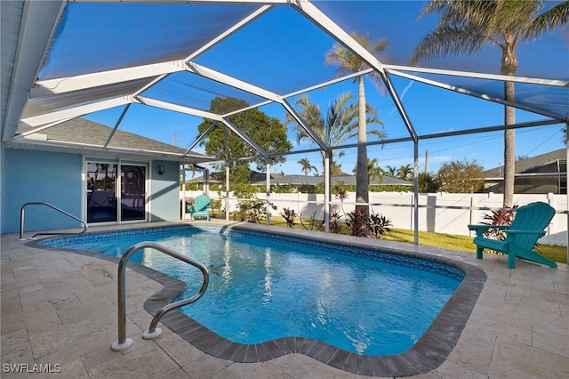 view of swimming pool featuring glass enclosure and a patio