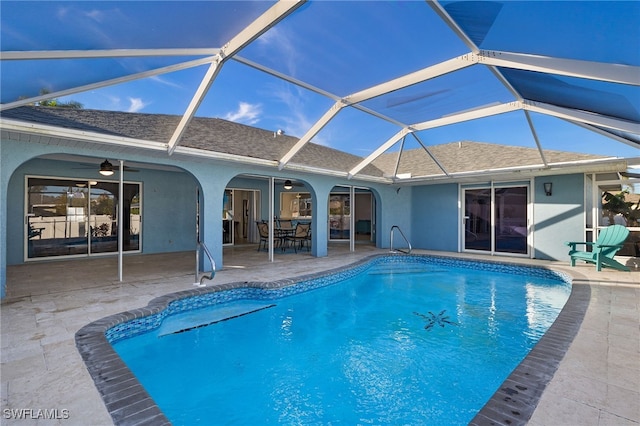 view of swimming pool featuring a lanai, ceiling fan, and a patio area