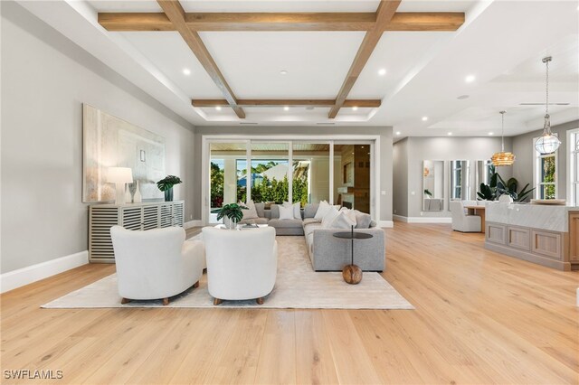 living room featuring beam ceiling, a healthy amount of sunlight, coffered ceiling, and light hardwood / wood-style floors