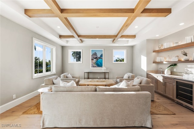 living room featuring wine cooler, beamed ceiling, light hardwood / wood-style floors, and coffered ceiling