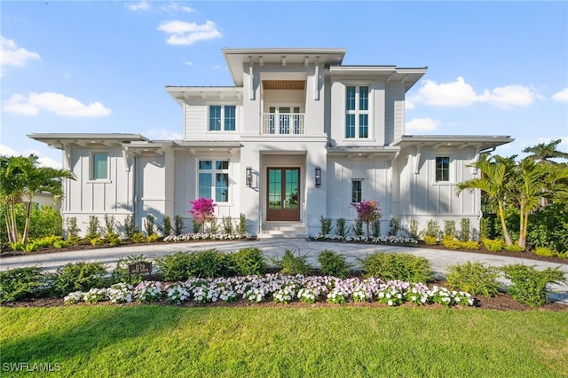 view of front facade with a balcony and a front lawn