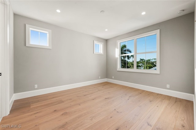 empty room with light hardwood / wood-style floors and a healthy amount of sunlight