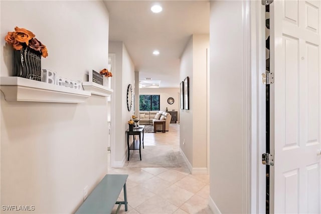 hall featuring light tile patterned floors, baseboards, and recessed lighting