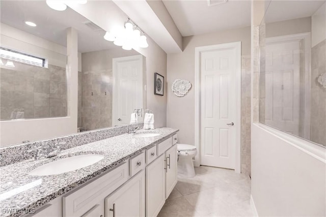 bathroom featuring walk in shower, a sink, toilet, and double vanity