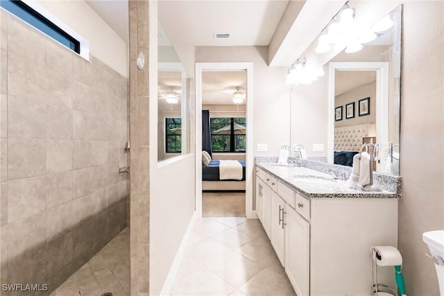 bathroom featuring tile patterned flooring, vanity, and walk in shower