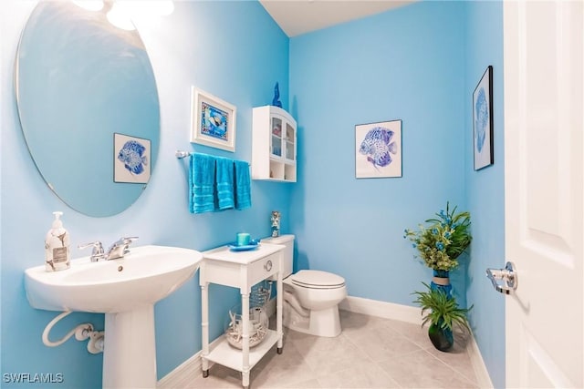 bathroom featuring baseboards, toilet, and tile patterned floors