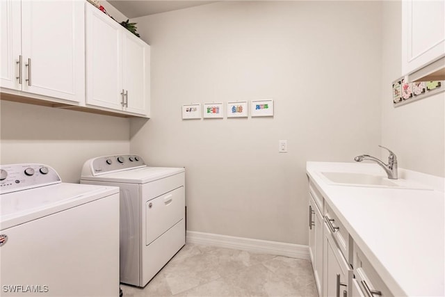 washroom with washing machine and clothes dryer, sink, and cabinets