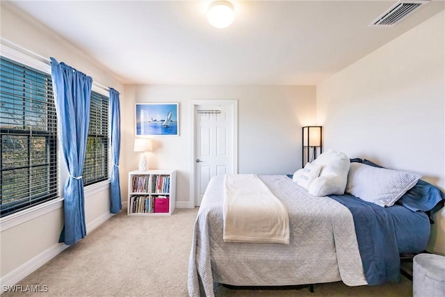 bedroom featuring baseboards, visible vents, and light colored carpet