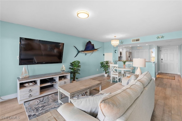 living room featuring a notable chandelier and light hardwood / wood-style floors