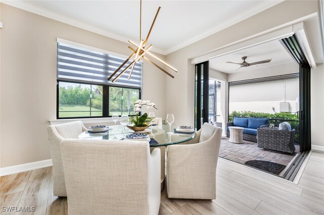 dining space with ceiling fan with notable chandelier, light hardwood / wood-style flooring, a wealth of natural light, and crown molding