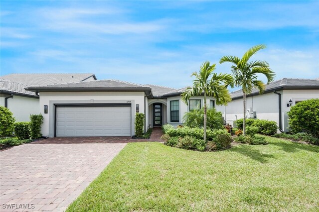 single story home featuring a garage and a front lawn