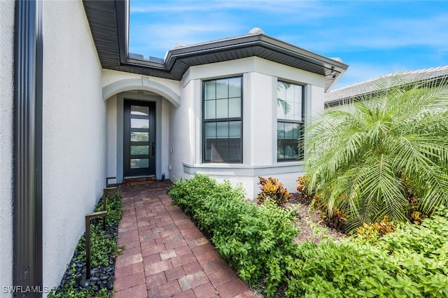 view of exterior entry featuring stucco siding