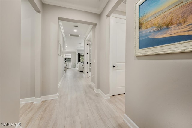 hall with visible vents, light wood-style flooring, and baseboards