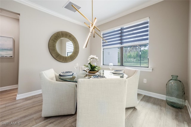 dining room featuring ornamental molding, visible vents, light wood-style flooring, and baseboards