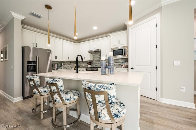 kitchen with white cabinets, decorative light fixtures, and stainless steel appliances