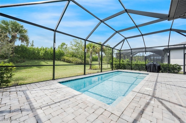 view of swimming pool featuring a lawn, glass enclosure, a grill, and a patio