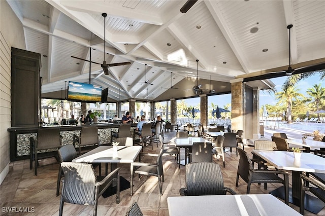 dining room featuring beamed ceiling, ceiling fan, and high vaulted ceiling