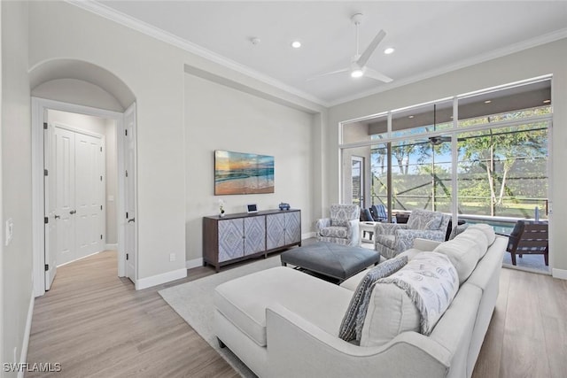 living room featuring ceiling fan, ornamental molding, and light hardwood / wood-style floors