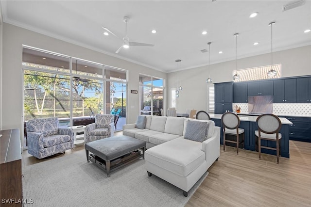 living room featuring ceiling fan, ornamental molding, and light hardwood / wood-style floors