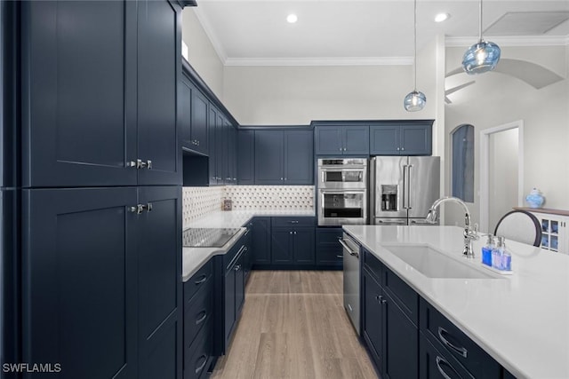 kitchen featuring sink, crown molding, backsplash, stainless steel appliances, and light hardwood / wood-style floors