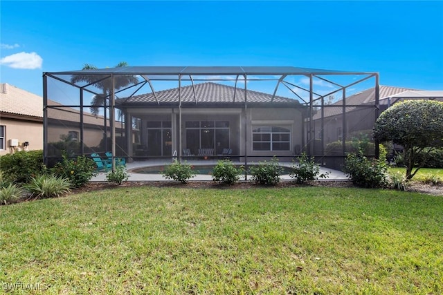 rear view of house with a yard and glass enclosure