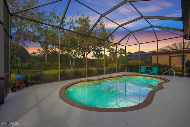 pool at dusk featuring a patio and a lanai