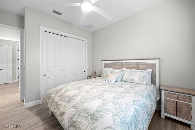 bedroom with ceiling fan, wood-type flooring, and a closet