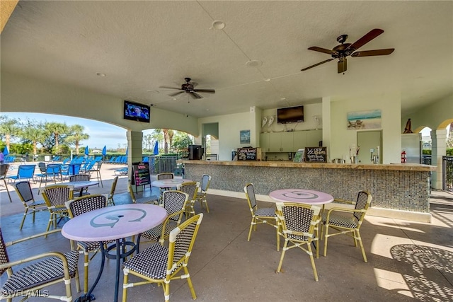 view of patio / terrace with ceiling fan and exterior bar