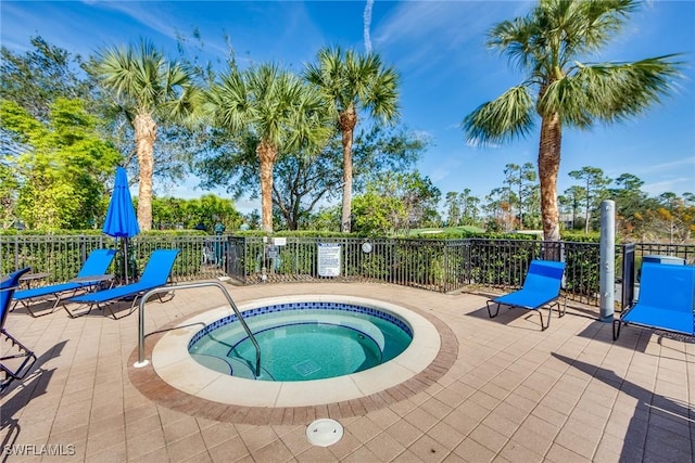 view of swimming pool featuring a hot tub and a patio