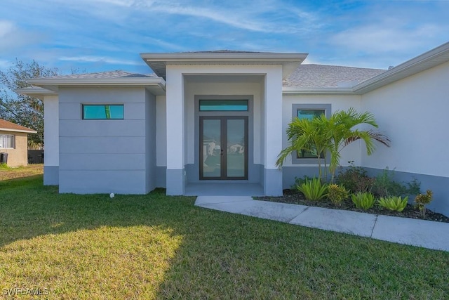 property entrance featuring a lawn and french doors