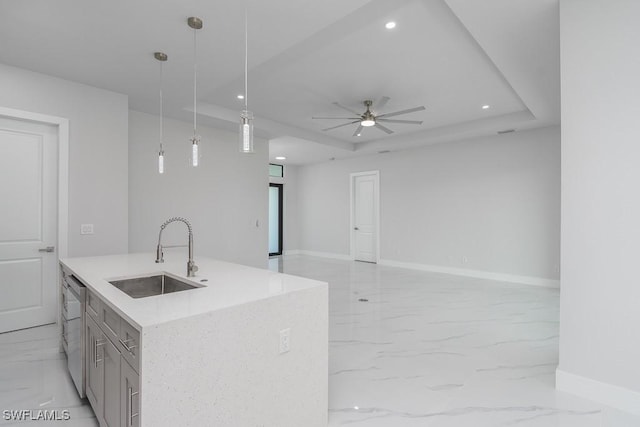 kitchen featuring stainless steel dishwasher, sink, hanging light fixtures, and a tray ceiling