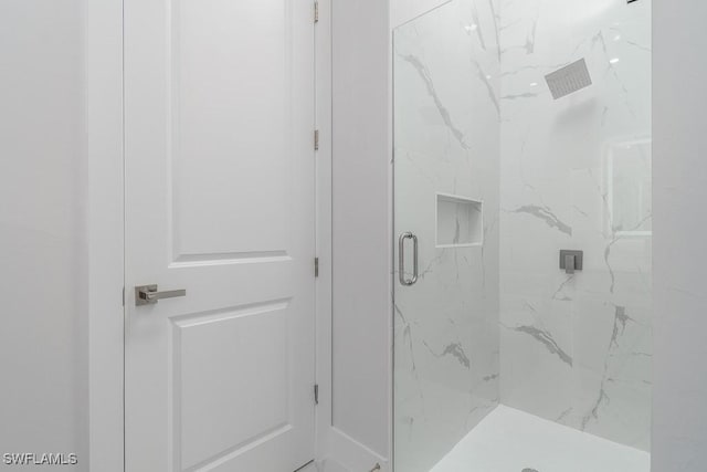 bathroom featuring a shower with door