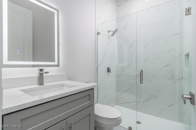 bathroom featuring vanity, toilet, and walk in shower