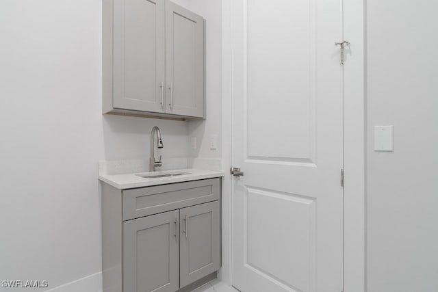 bar featuring gray cabinetry and sink