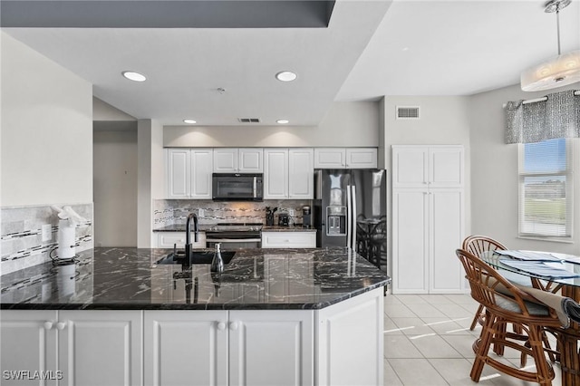 kitchen with white cabinetry, sink, dark stone counters, light tile patterned flooring, and appliances with stainless steel finishes