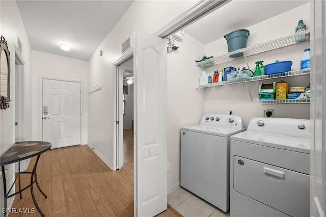 laundry area with washer and dryer, light wood-type flooring, and ceiling fan