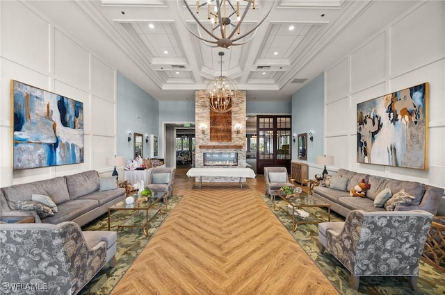 living room with beamed ceiling, a high ceiling, coffered ceiling, and a notable chandelier