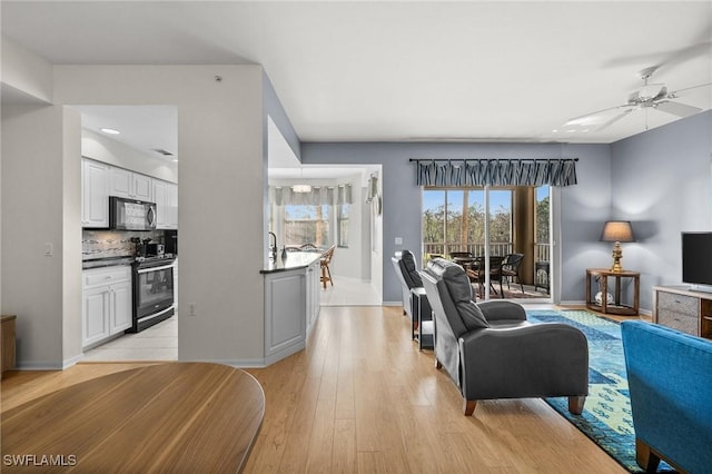 living room featuring ceiling fan and light hardwood / wood-style flooring