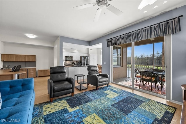 living room featuring radiator heating unit, light hardwood / wood-style floors, and ceiling fan