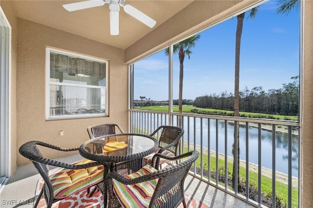 sunroom / solarium featuring ceiling fan and a water view